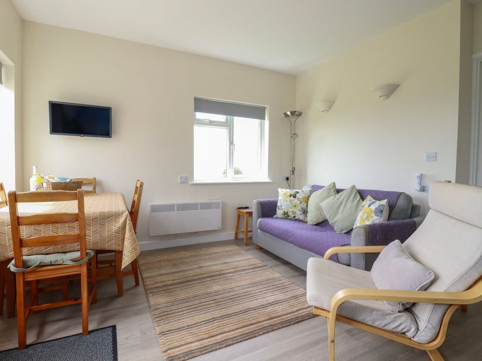 A living room with a sofa and dining table at Kitticarn in Sennen Cove near St Just