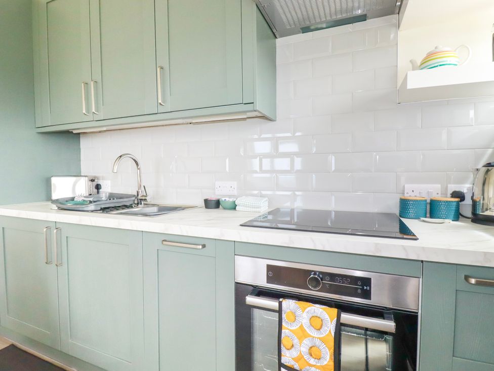 A kitchen with a stove, sink, oven, and cabinets at Kitticarn in Sennen Cove near St Just
