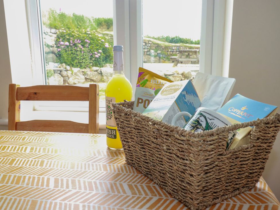 A basket with snacks and a drink on a table at Kitticarn in Sennen Cove near St Just