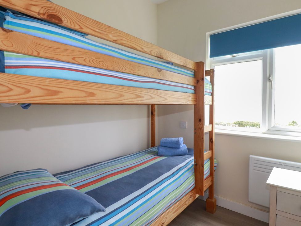 A bunk bed with striped bedding and towels in a bedroom at Kitticarn in Sennen Cove near St Just