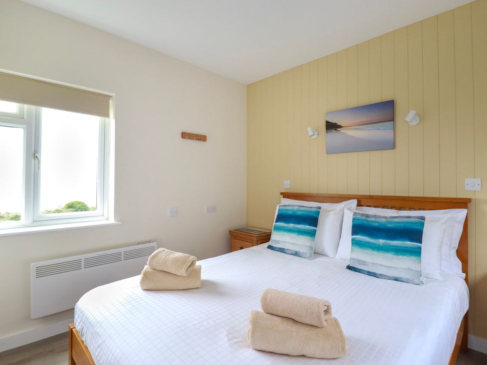 A bedroom with a bed and towels at Kitticarn in Sennen Cove near St Just