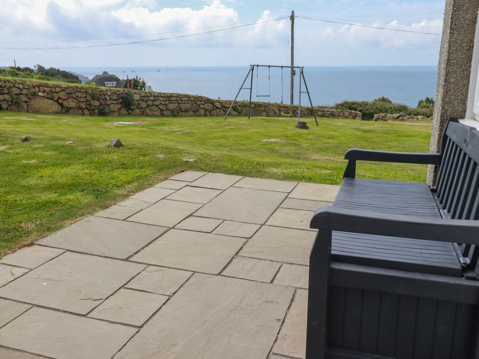 An outdoor area with a swing set and stone wall at Kitticarn Sennen Cove near St Just