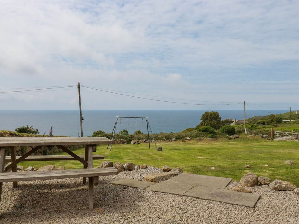 A garden with a picnic table and swing set at Kitticarn Sennen Cove near St Just