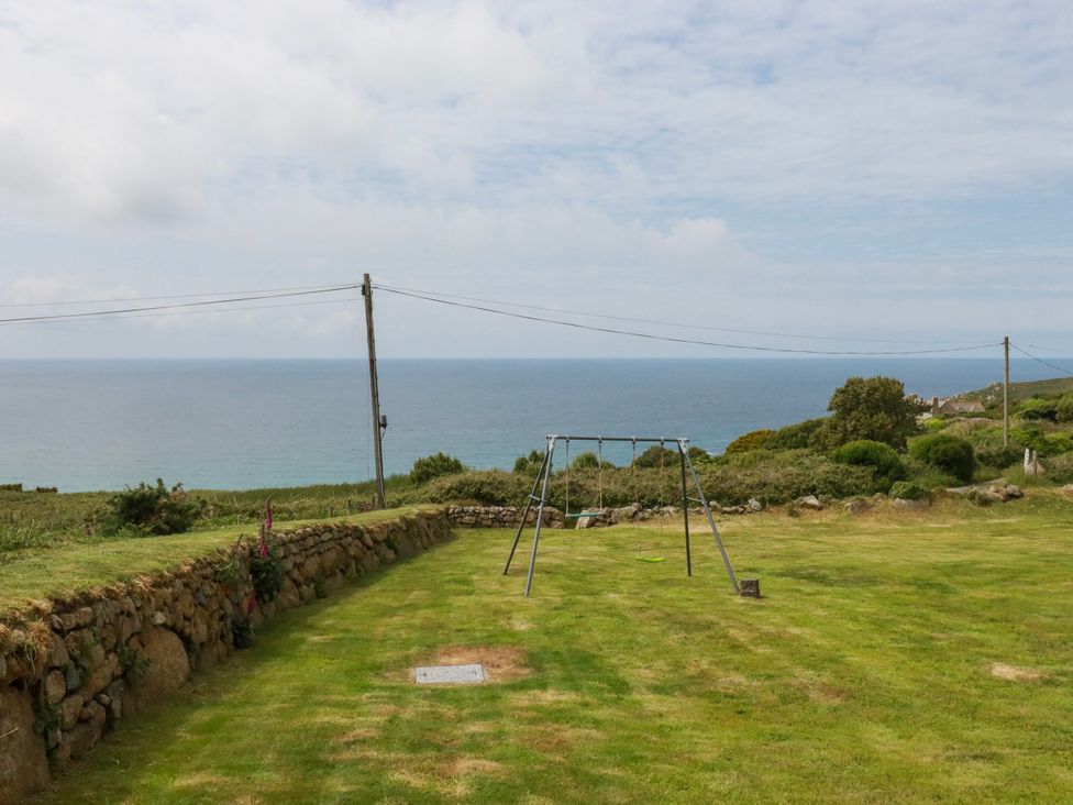 A garden with a swing set overlooking the ocean at Kitticarn in Sennen Cove near St Just