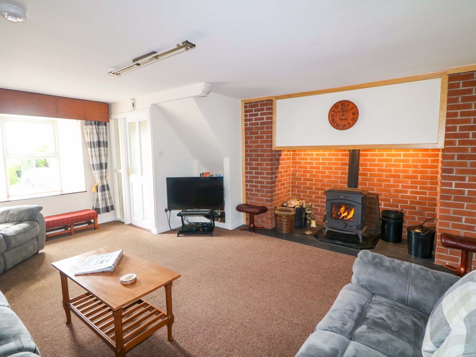 A living room with a fireplace and seating area at Curradoon House, Touraneena, County Waterford