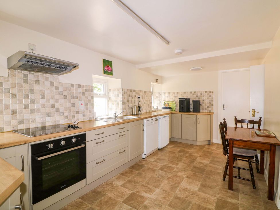 A kitchen with an oven and a table at Curradoon House in Touraneena, County Waterford