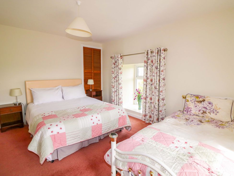 A bedroom with two beds and a window at Curradoon House in Touraneena, County Waterford