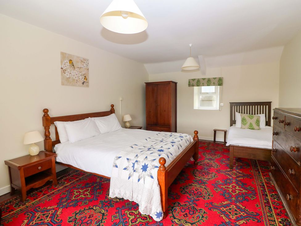 A bedroom with a double bed and single bed at Curradoon House in Touraneena, County Waterford
