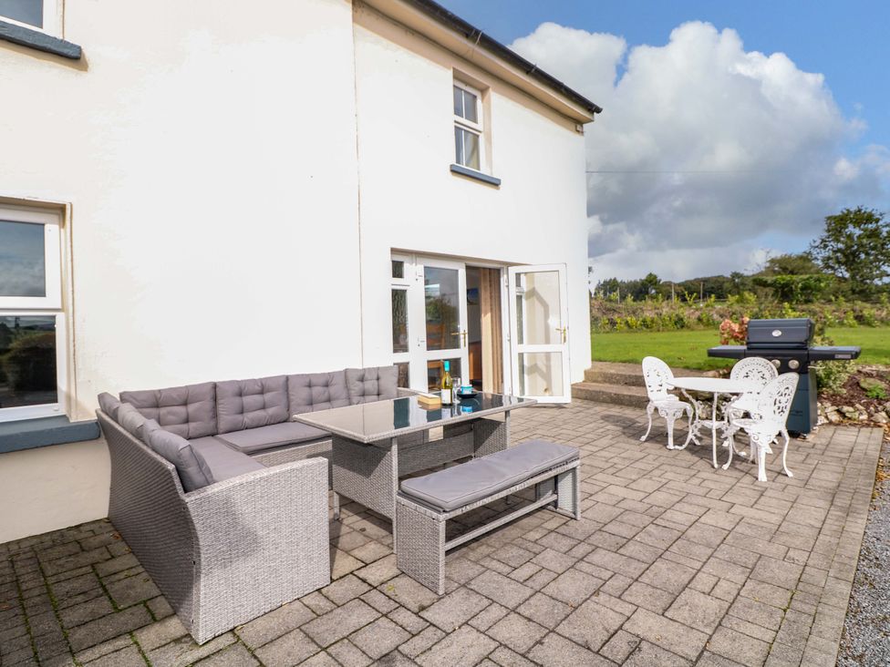 A patio with an outdoor sofa and dining table at Curradoon House in Touraneena, County Waterford