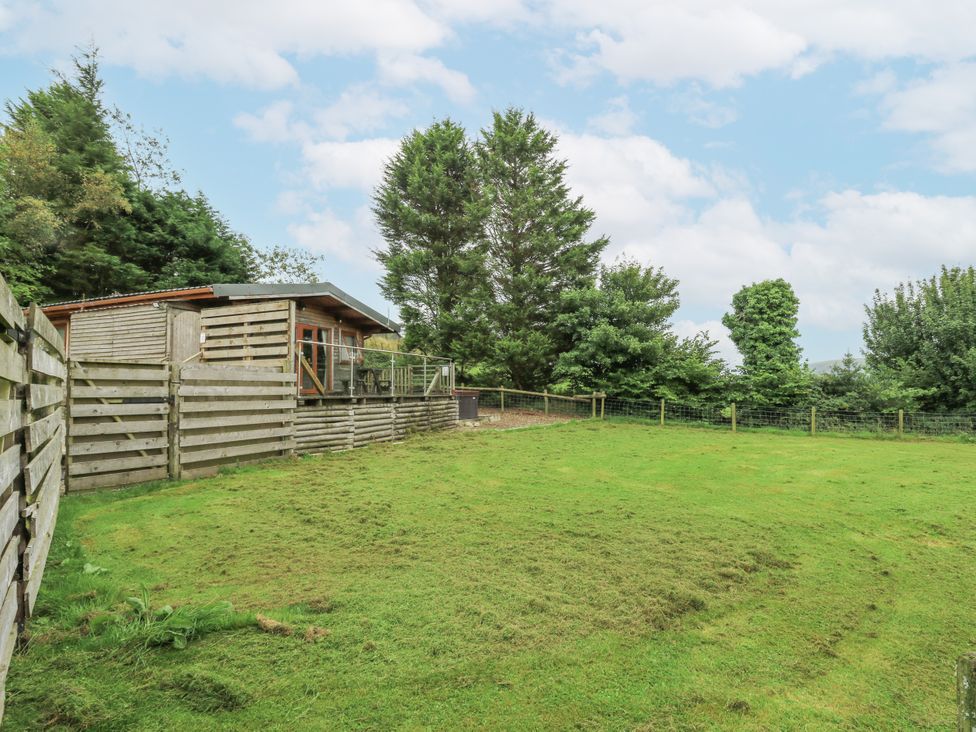 A cabin with a patio and grass area at The Cabin in Pontardawe