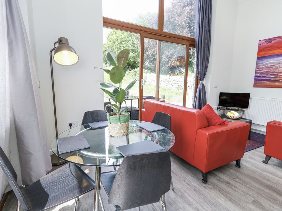 A living room with a glass table and chairs at Budmouth near Weymouth