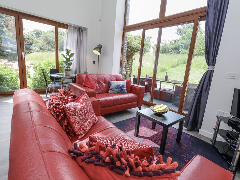 A living room with red sofa and coffee table at Budmouth in Upwey near Weymouth