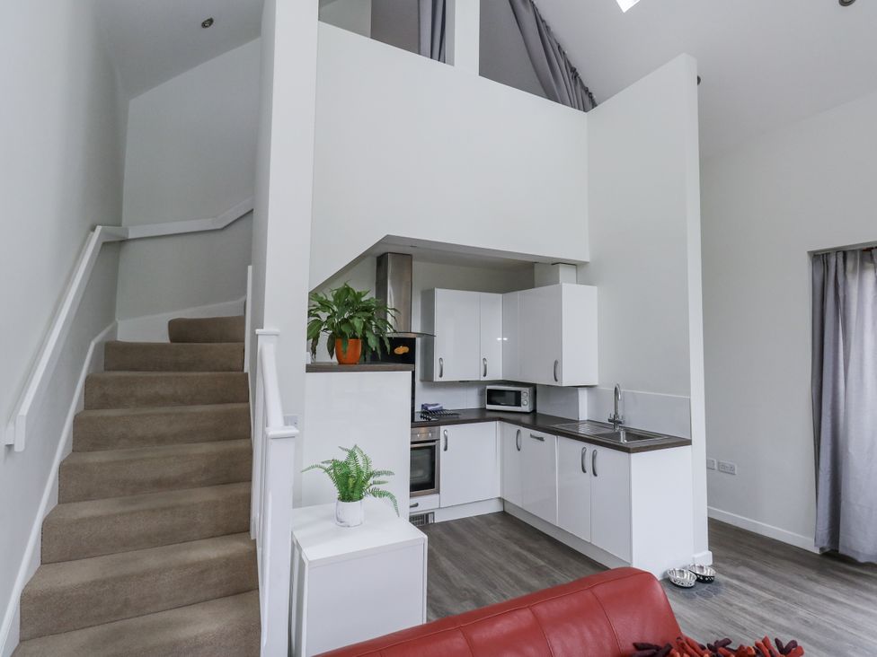 A kitchen with a staircase and seating area at Budmouth in Upwey near Weymouth