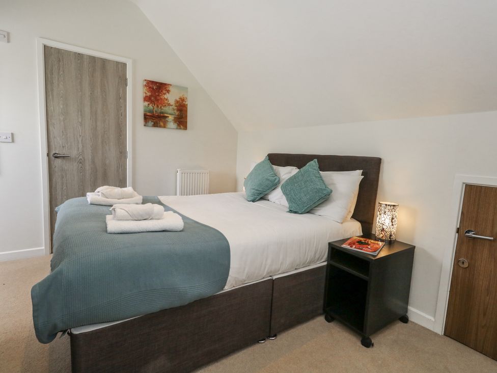 A bedroom with a bed and bedside table at Budmouth in Upwey near Weymouth