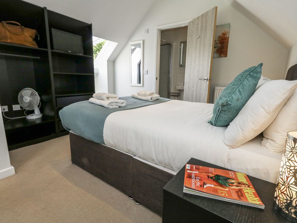 A bedroom with a bed and shelves at Budmouth near Weymouth
