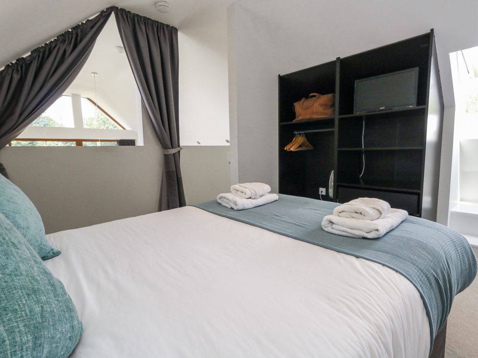 A bedroom with a bed and shelves at Budmouth in Upwey near Weymouth