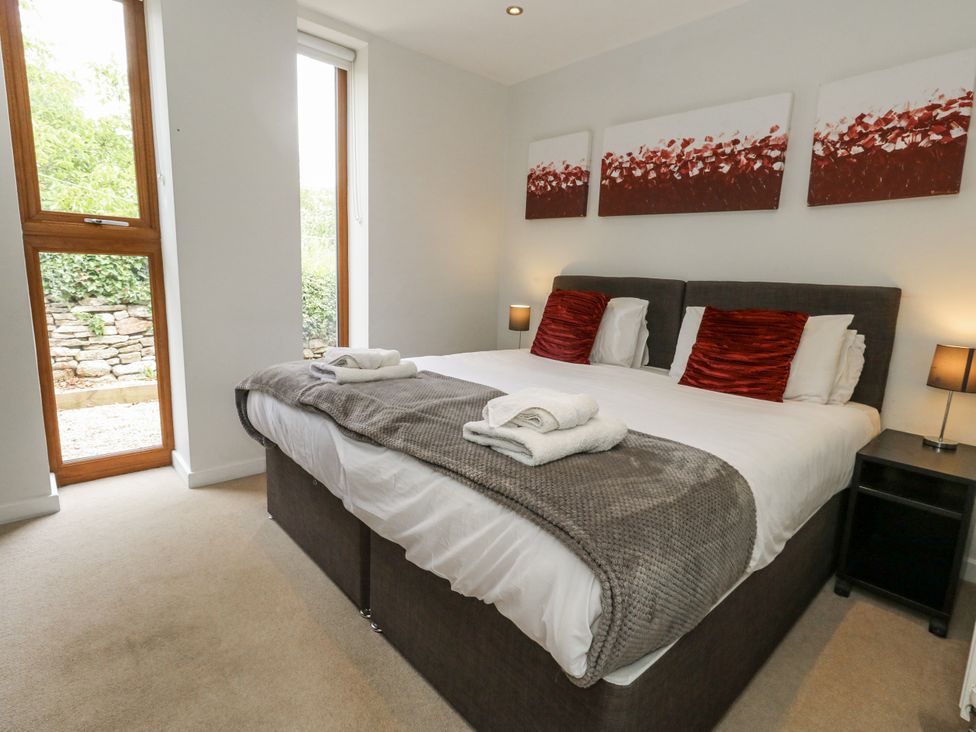 A bedroom with a double bed and windows at Budmouth in Upwey near Weymouth