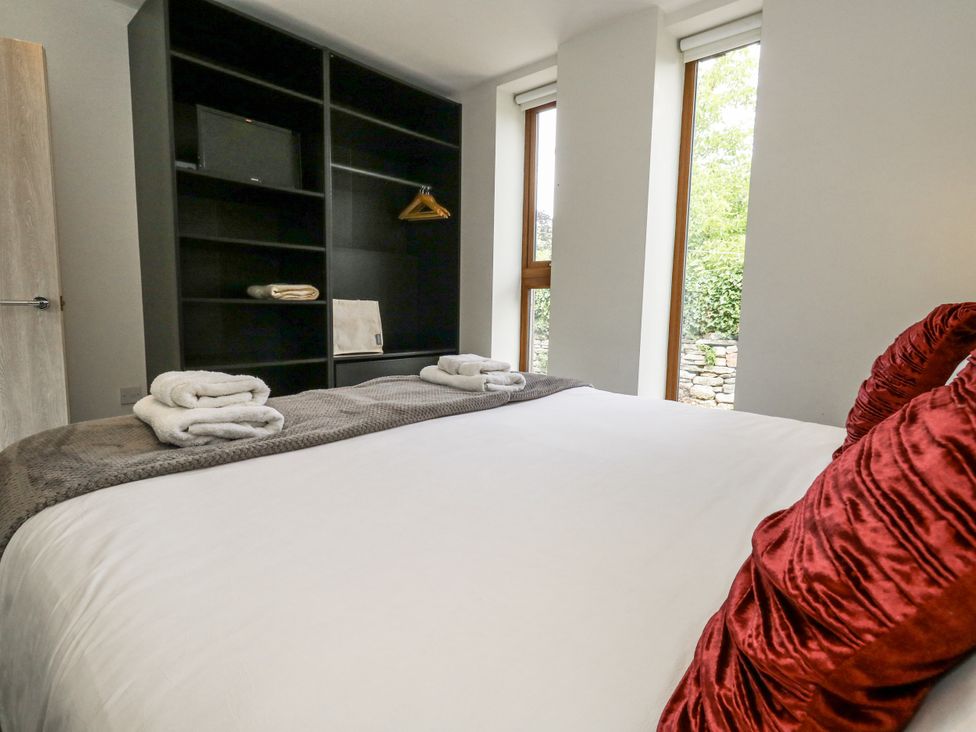 A bedroom with a bed and shelves at Budmouth Upwey near Weymouth