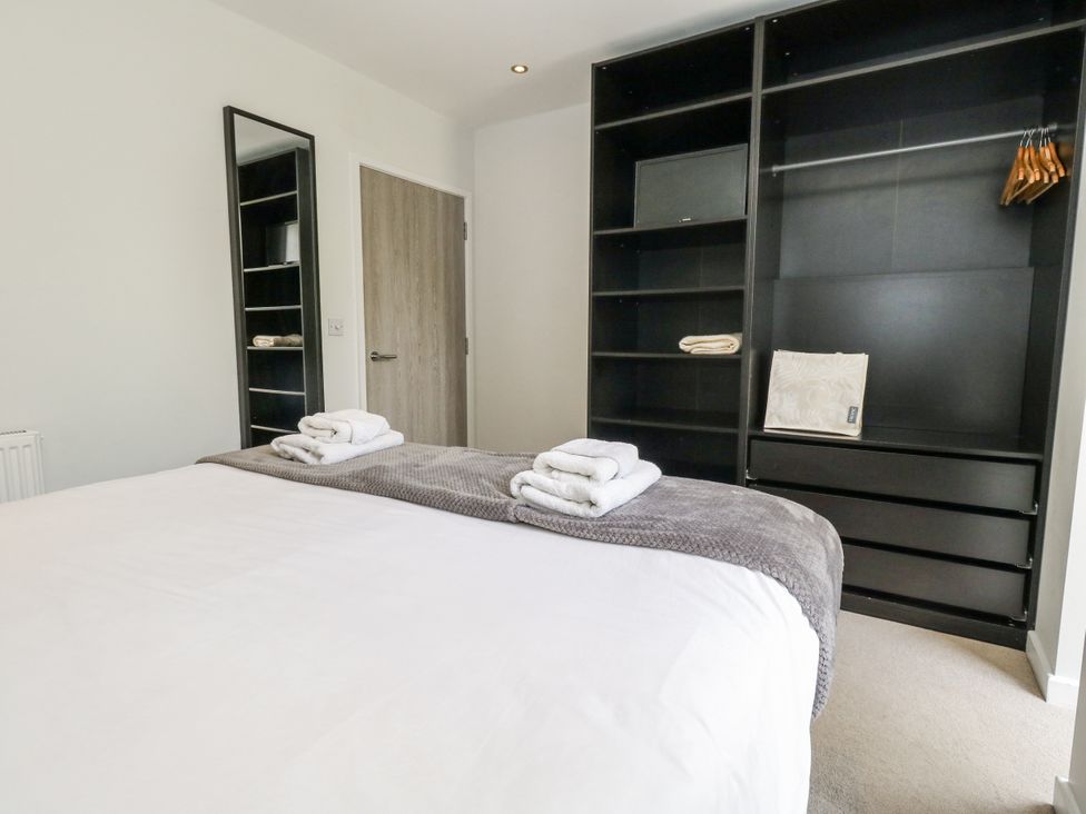 A bedroom with a bed and storage unit at Budmouth in Upwey near Weymouth