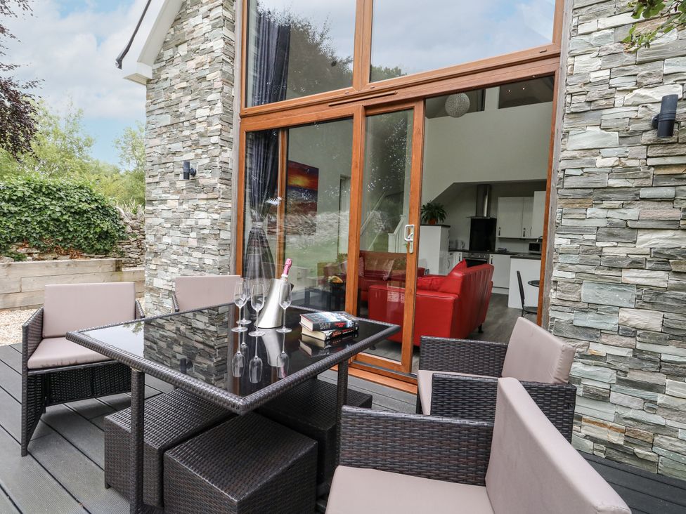 An outdoor patio area with a dining table and chairs at Budmouth in Upwey near Weymouth