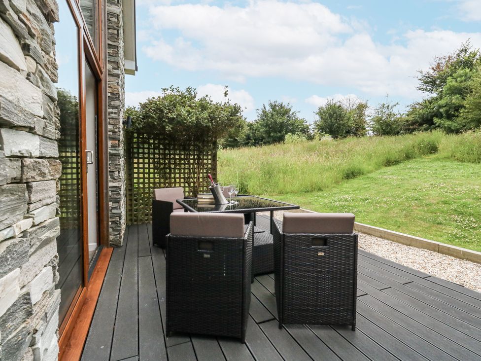 A garden with a table and chairs on a deck at Budmouth Upwey near Weymouth
