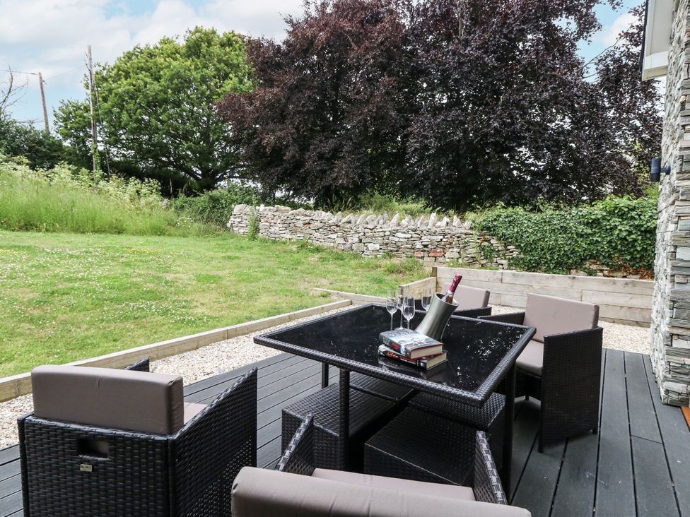 An outdoor patio with a table and chairs at Budmouth in Upwey near Weymouth
