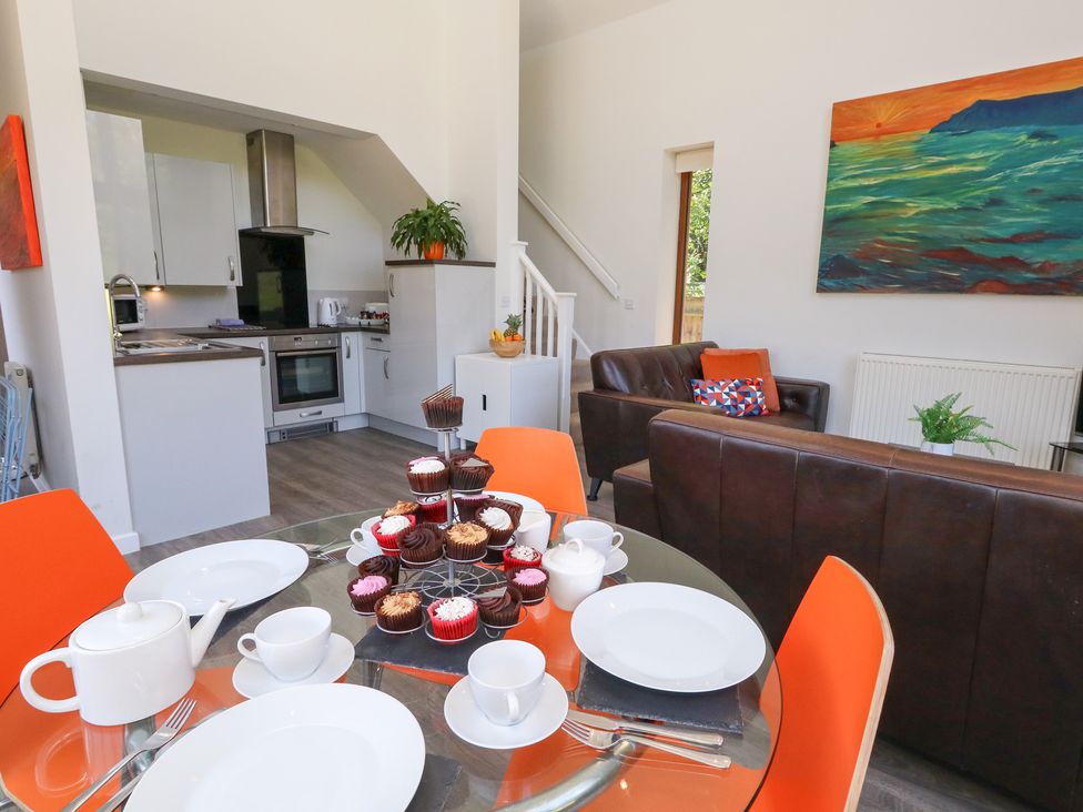 A kitchen with a dining table and cupcakes at Shepherd Oak in Upwey near Weymouth