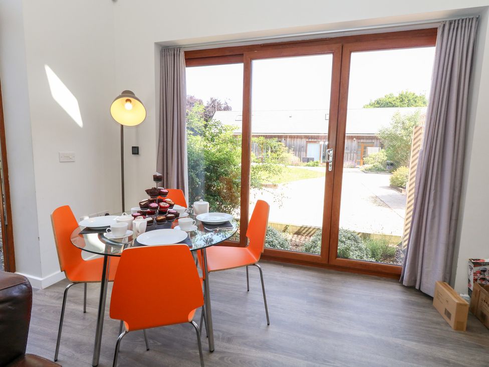 A dining room with a table and chairs at Shepherd Oak in Upwey near Weymouth