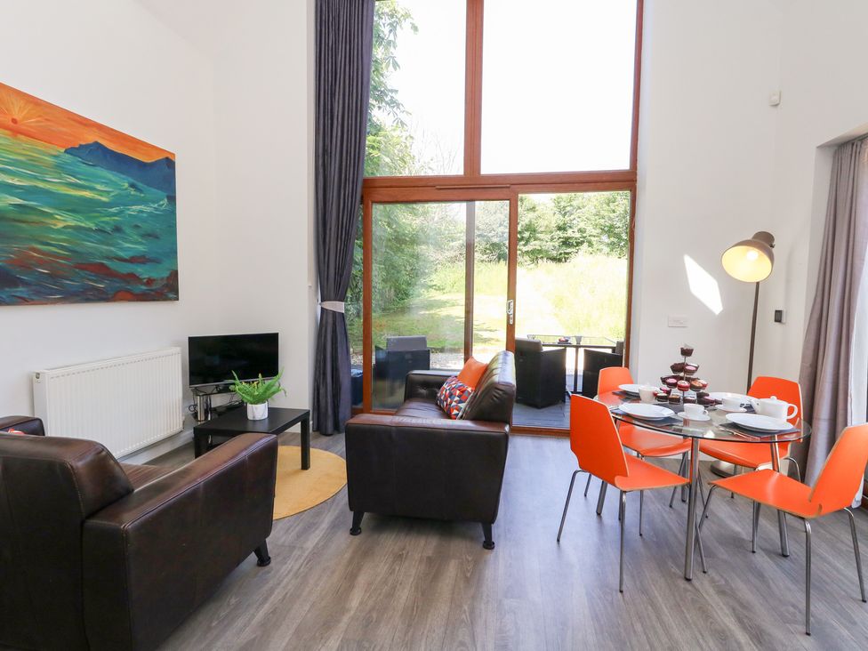 A living room with a sofa and dining area at Shepherd Oak Upwey near Weymouth