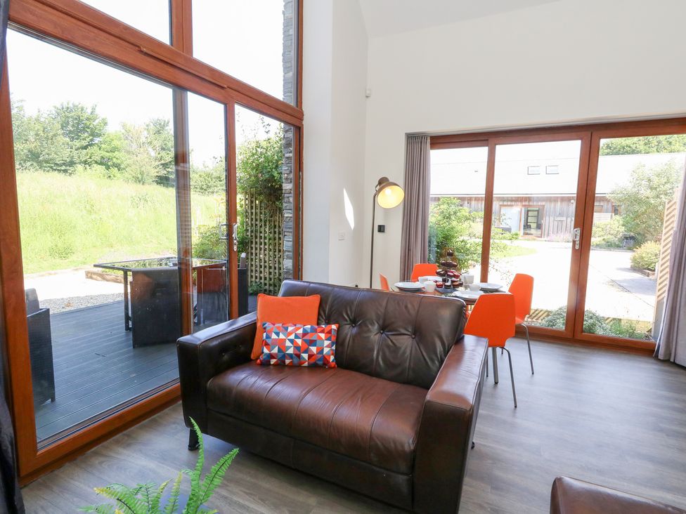 A living room with a couch and dining area at Shepherd Oak in Upwey near Weymouth