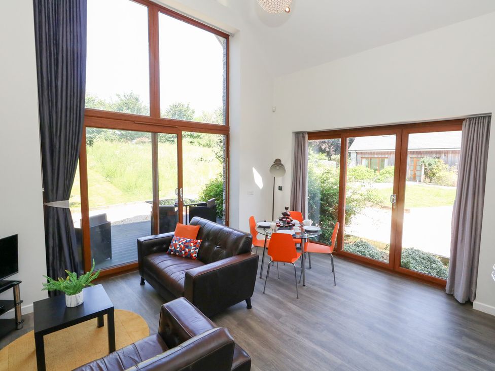 A living room with a sofa and dining area at Shepherd Oak Upwey near Weymouth