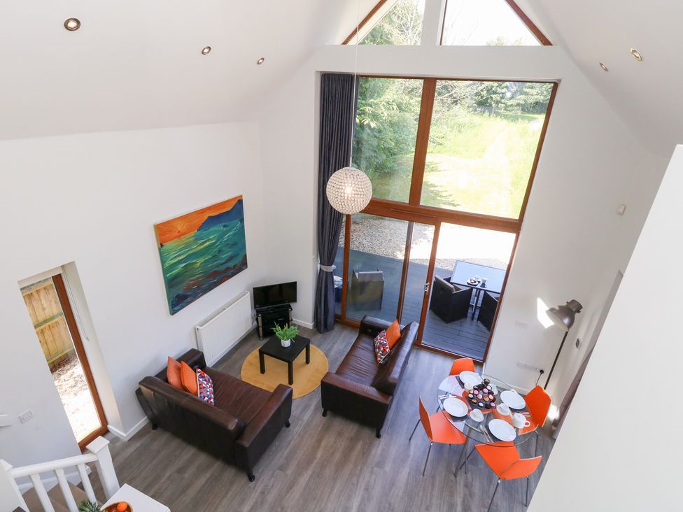 A living room with a sofa and a dining area at Shepherd Oak Upwey near Weymouth