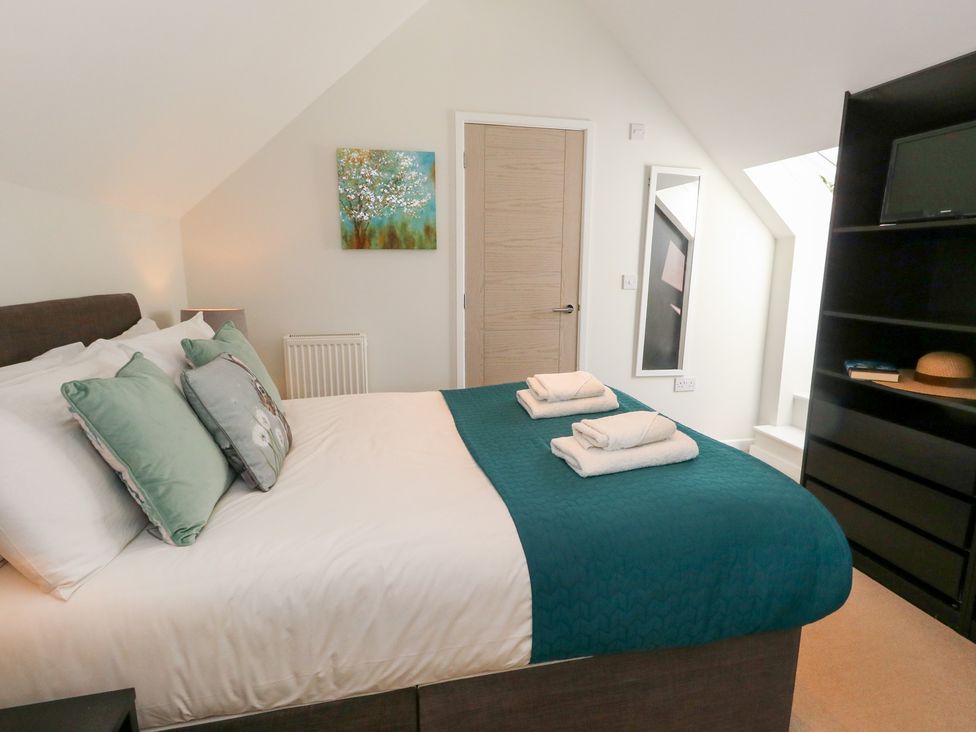 A bedroom with a bed and towels on it at Shepherd Oak in Upwey near Weymouth