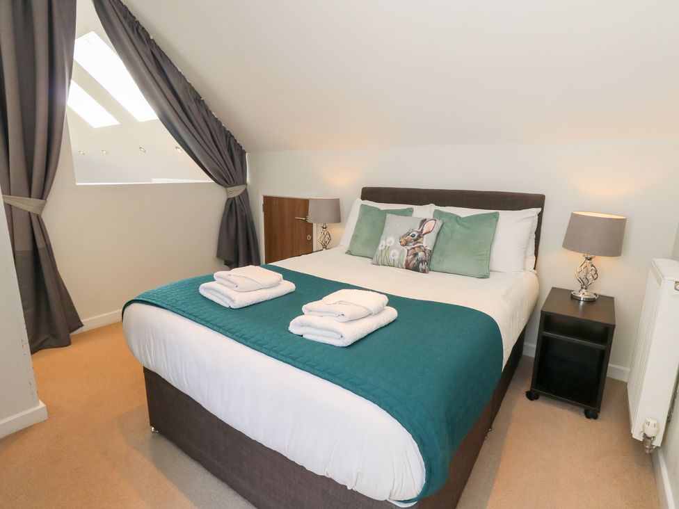 A bedroom with a bed and window at Shepherd Oak Upwey near Weymouth