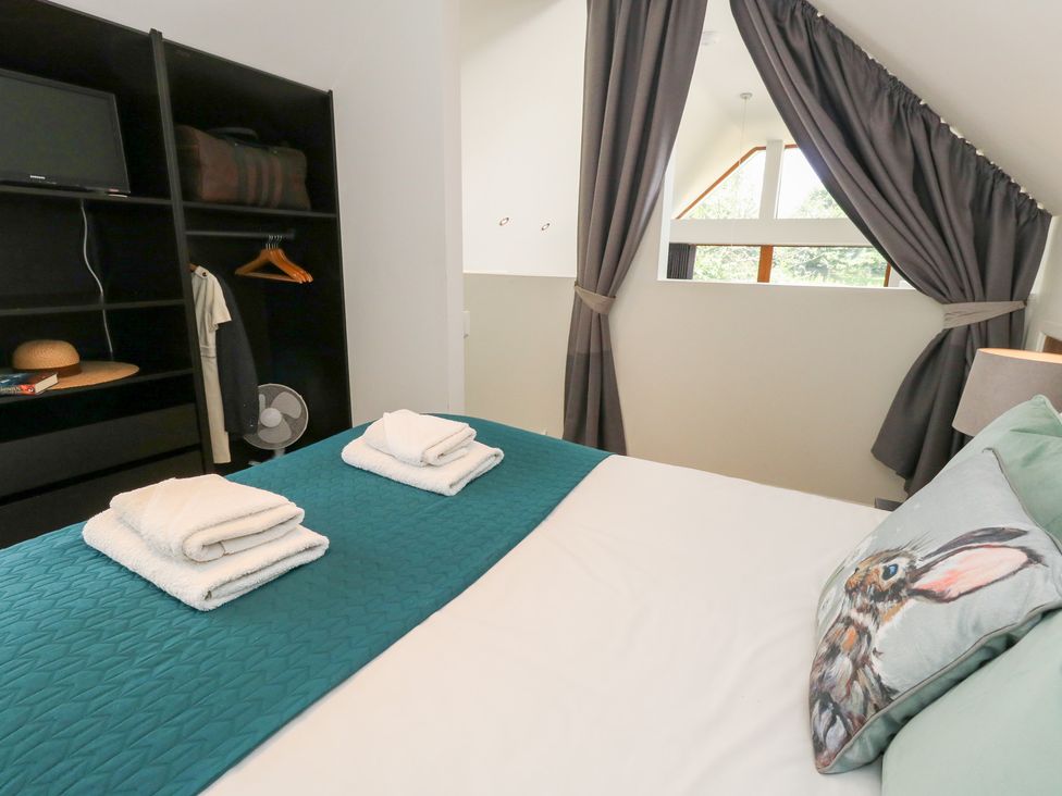 A bedroom with a bed and storage at Shepherd Oak in Upwey near Weymouth