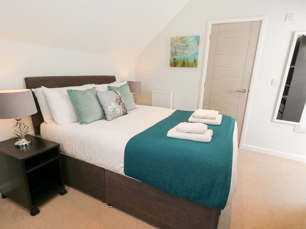A bedroom with a bed and nightstand at Shepherd Oak in Upwey near Weymouth