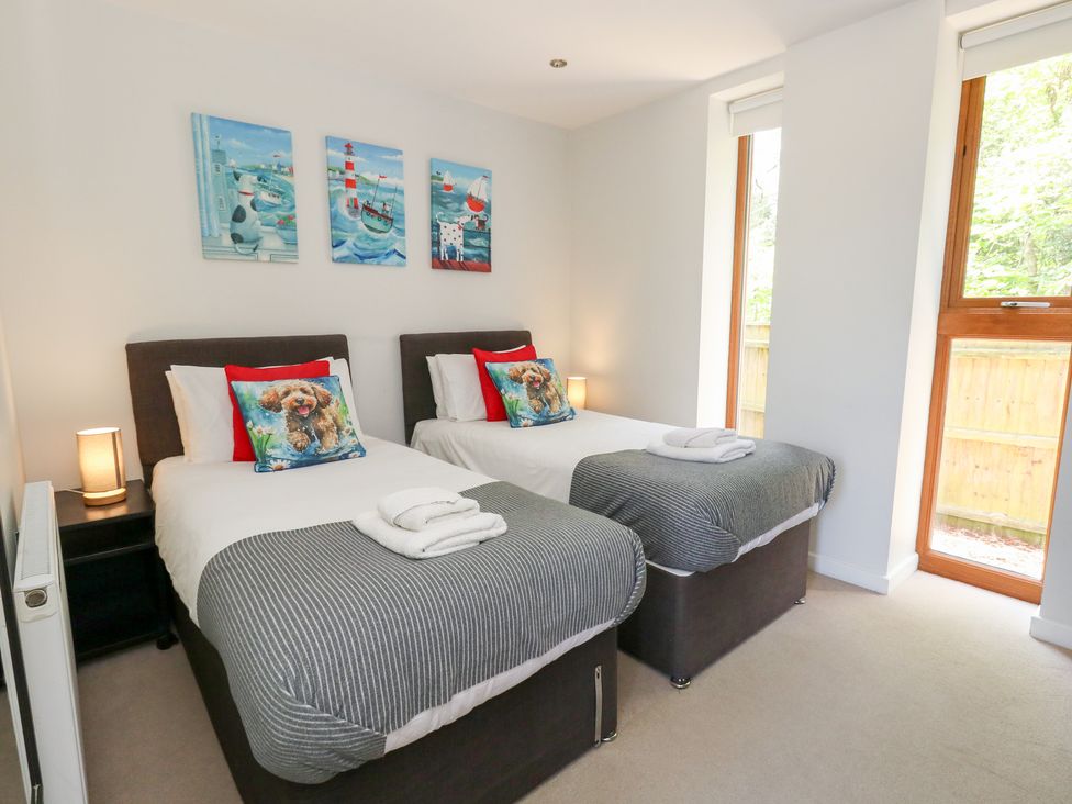 A bedroom with twin beds and large windows at Shepherd Oak in Upwey near Weymouth
