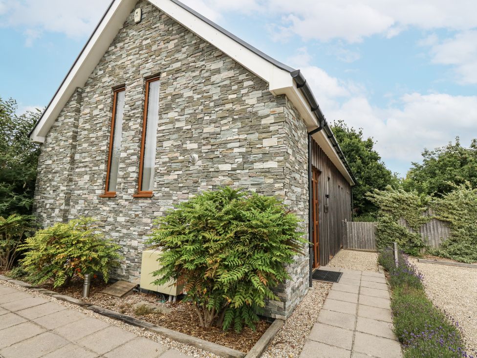 Exterior view of a house with stone wall and bushes at Everdene Upwey near Weymouth