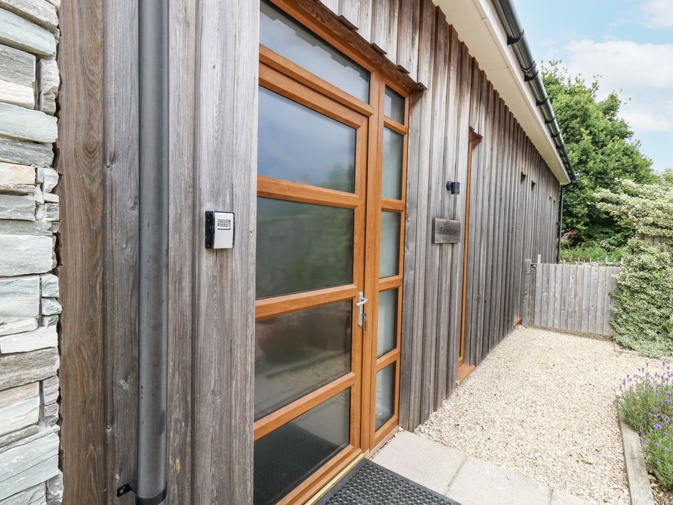 An entrance to a house with a wooden door and stone wall at Everdene Upwey near Weymouth