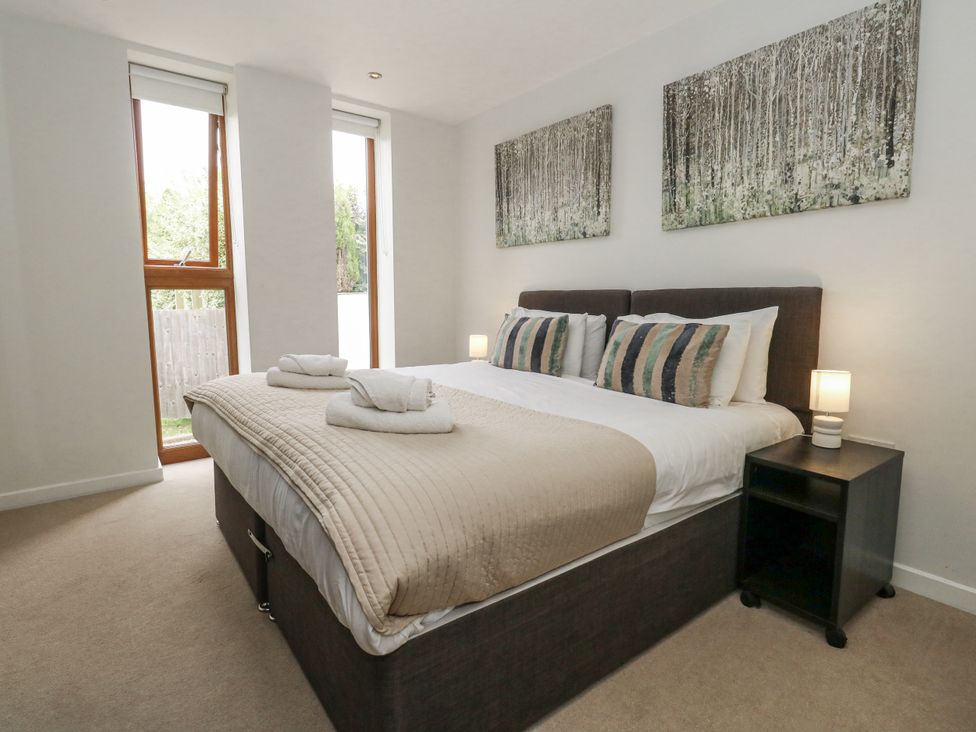 A bedroom with a bed and two windows at Everdene Upwey near Weymouth