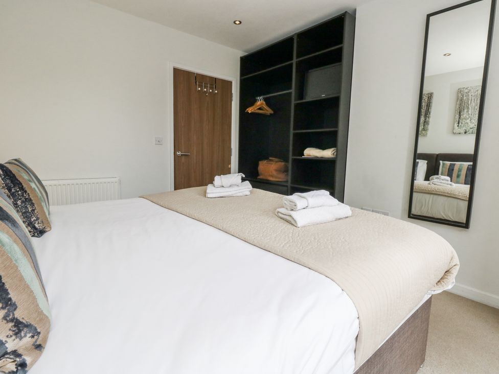 A bedroom with a bed and wardrobe at Everdene Upwey near Weymouth