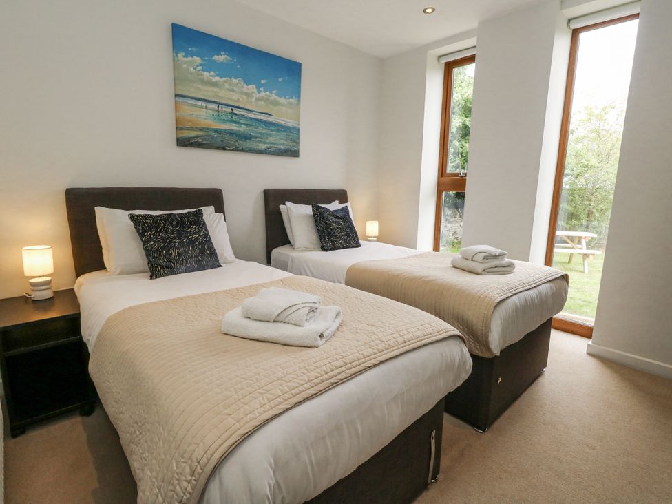 A bedroom with two beds and a window at Everdene in Upwey near Weymouth