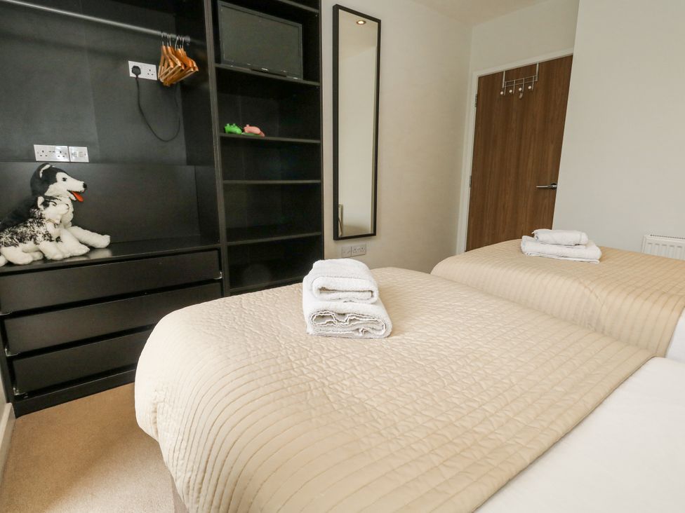 A bedroom with twin beds and a mirror at Everdene in Upwey near Weymouth