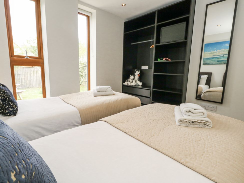 A bedroom with two beds and a mirror at Everdene Upwey near Weymouth