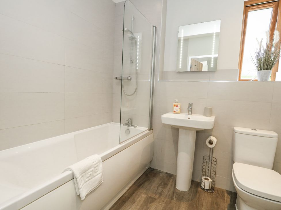 A bathroom with a shower and bathtub at Everdene in Upwey near Weymouth