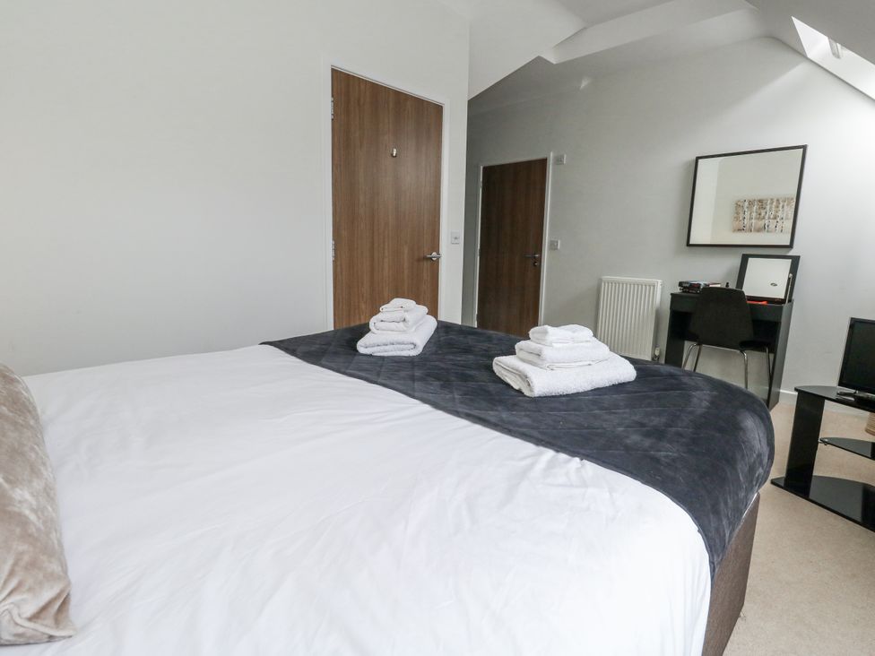 A bedroom with a bed and desk at Everdene in Upwey near Weymouth