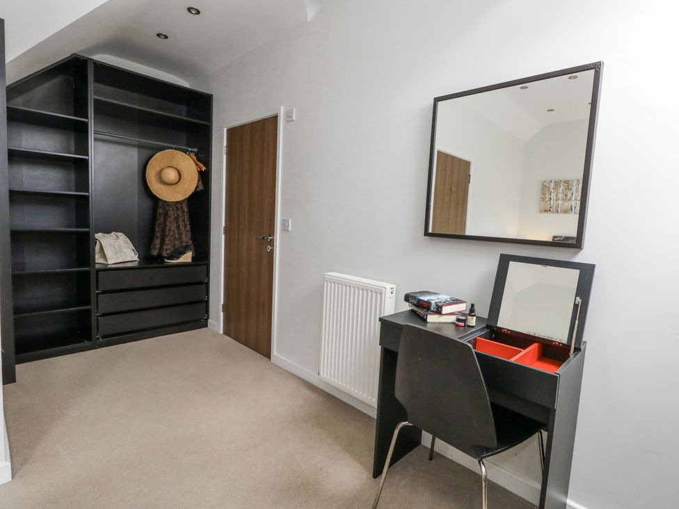 A bedroom with a desk and mirror at Everdene Upwey near Weymouth