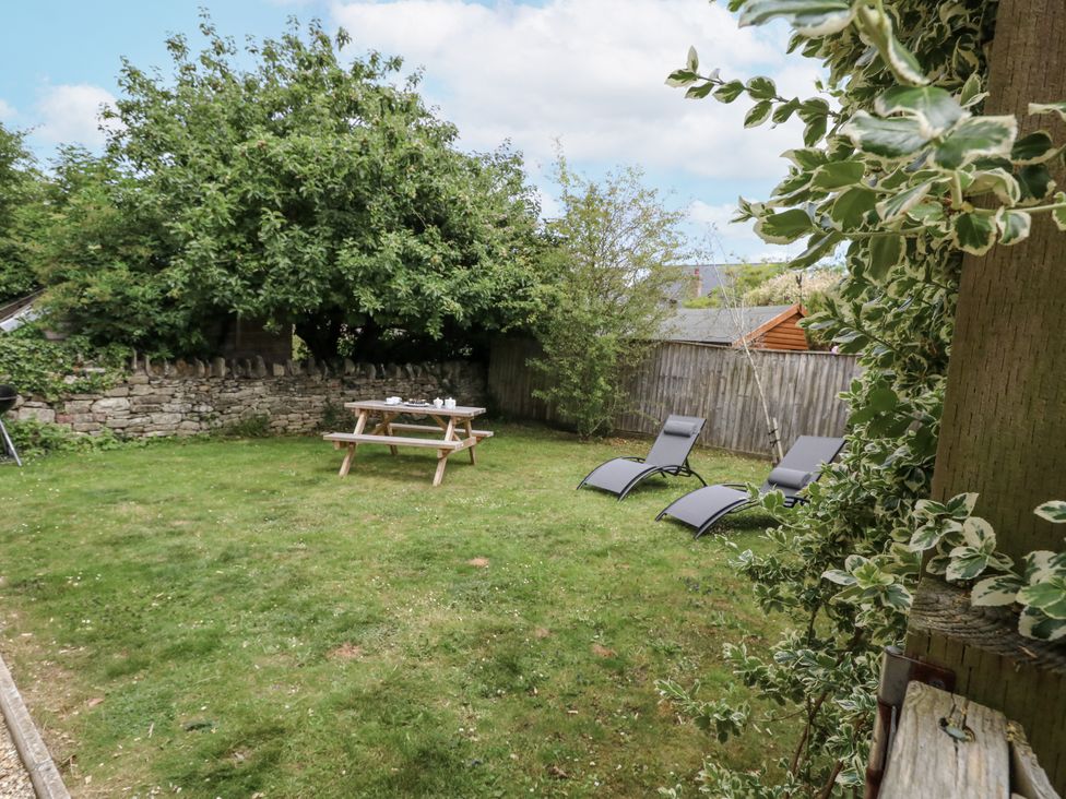 A garden with a picnic table and deck chairs at Everdene Upwey near Weymouth