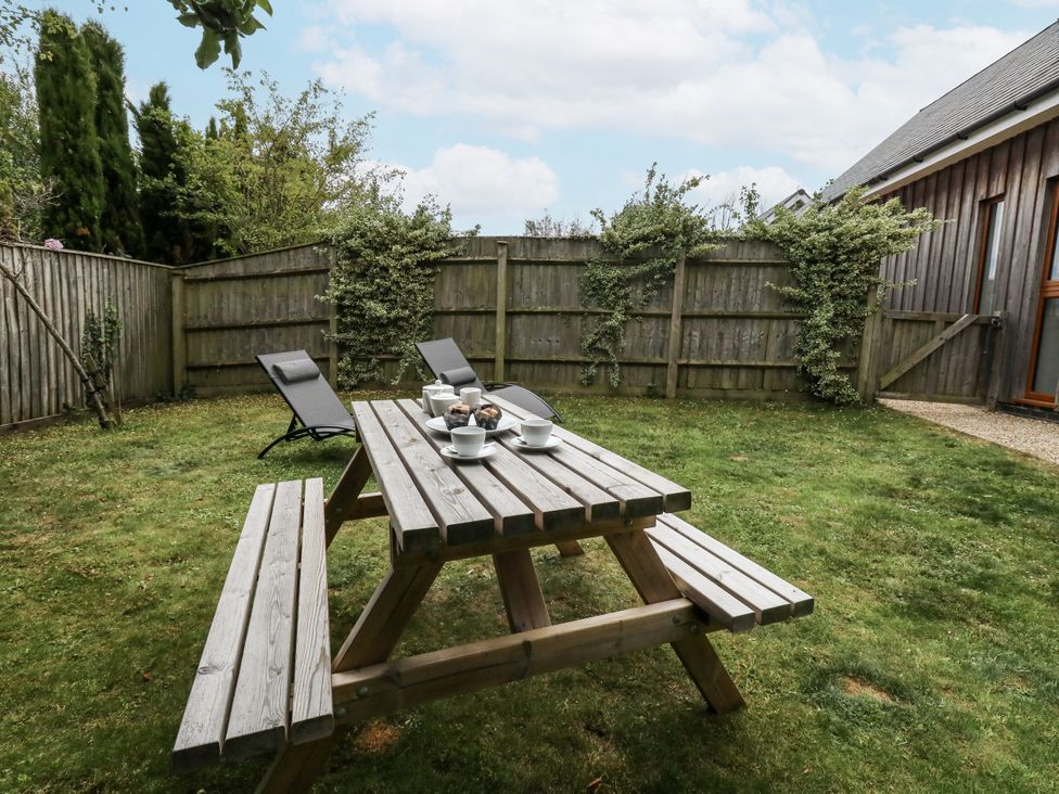 A garden with a picnic table and chairs at Everdene in Upwey near Weymouth