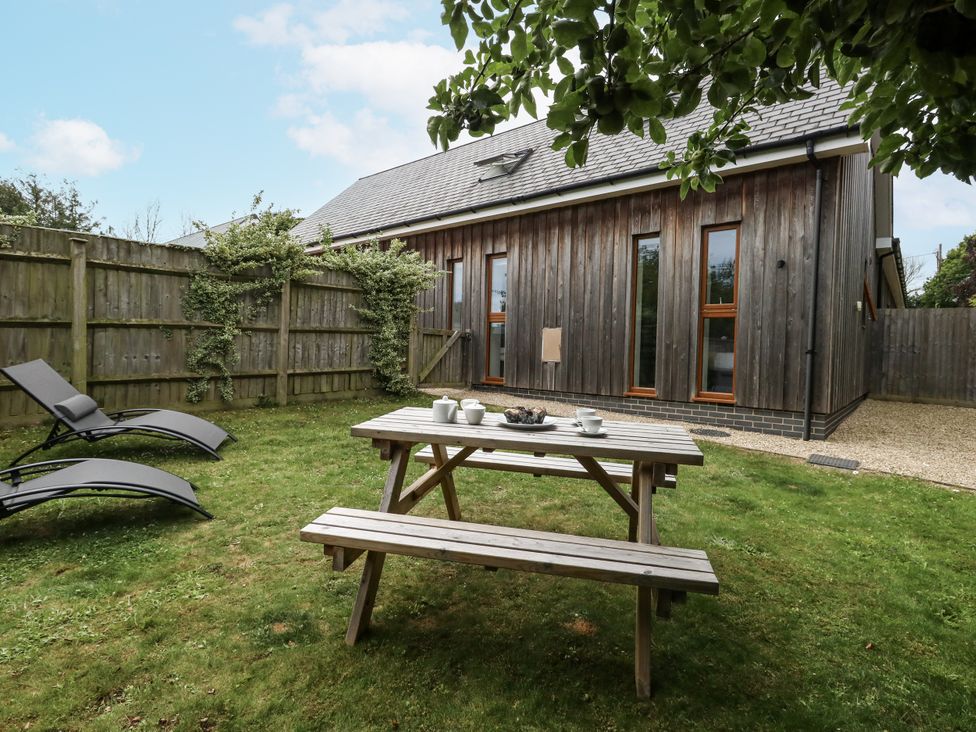 A garden with a picnic table and deck chairs at Everdene Upwey near Weymouth